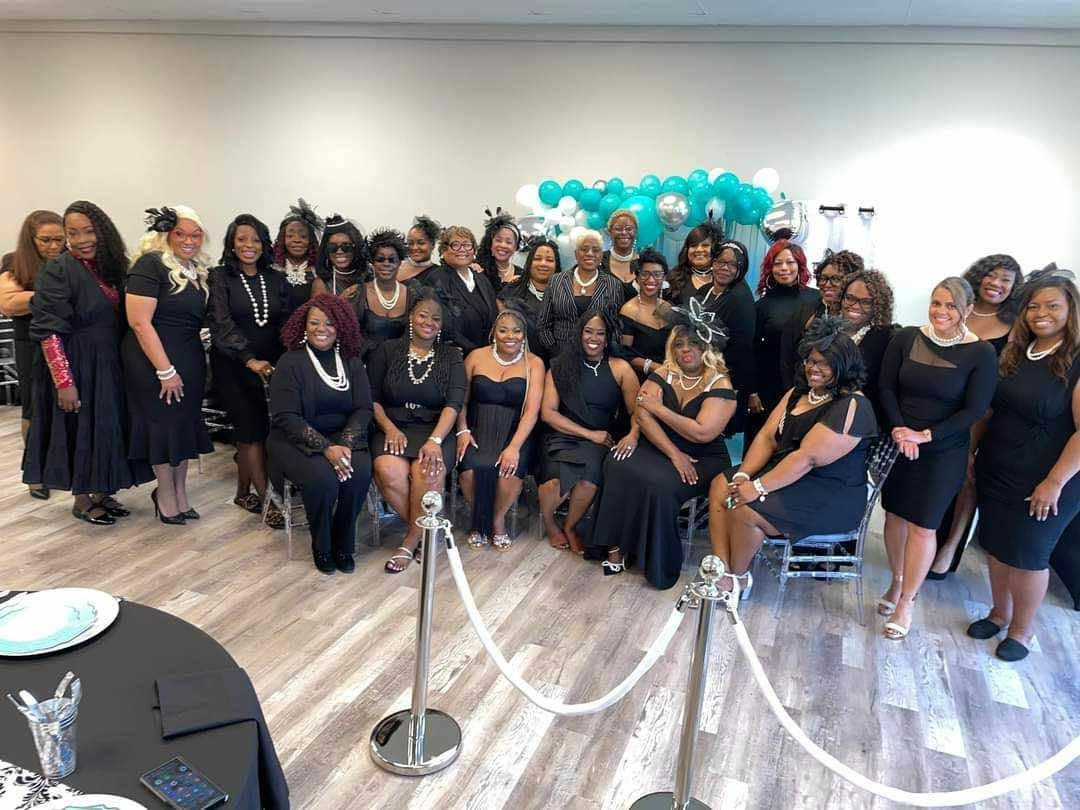 Members in black attire and pearls at a past event