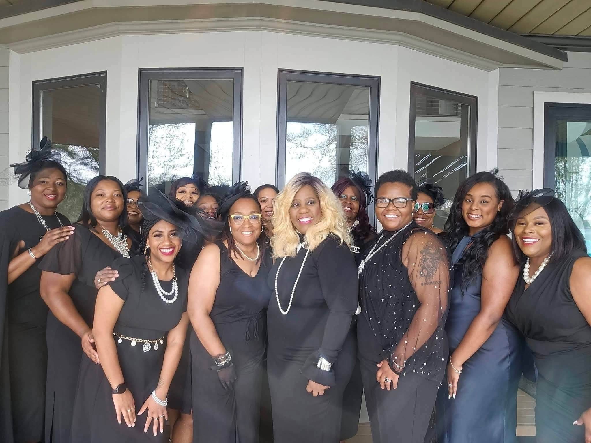 Members posing together on a porch at a past event